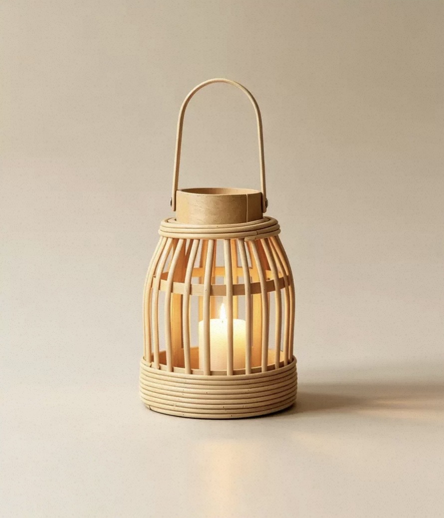 Bamboo cage lantern with a rattan base and lit pillar candle