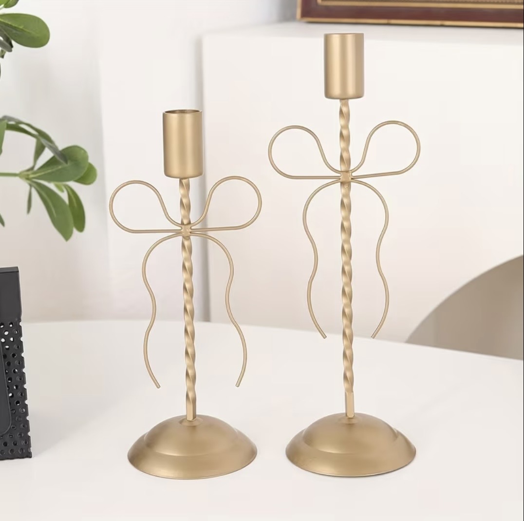 Gold bow-detail candlesticks with twisted stems in two heights