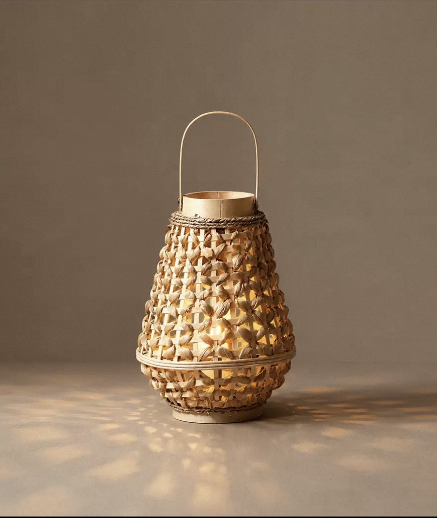 Teardrop woven bamboo lantern with a rope-wrapped handle and lit candle