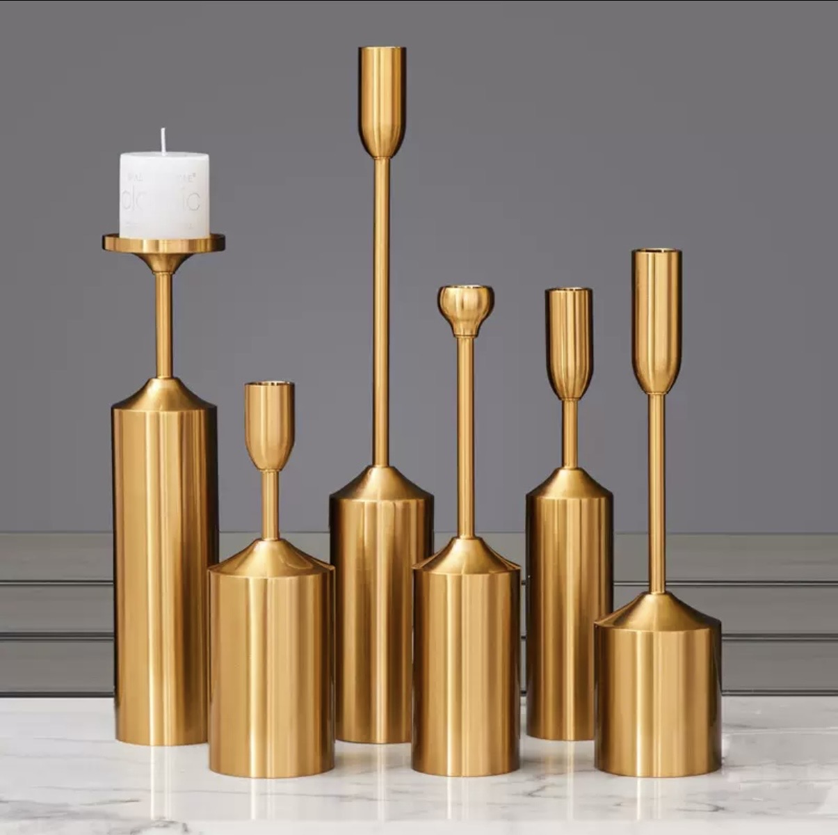 Brushed gold cylindrical candle holders in assorted heights