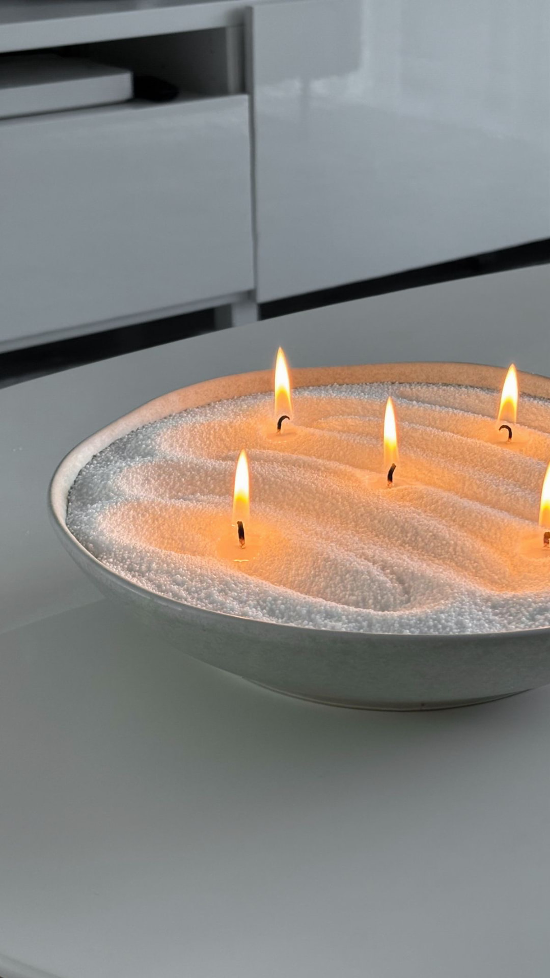 Ivory candle sand arranged in waves with multiple flames