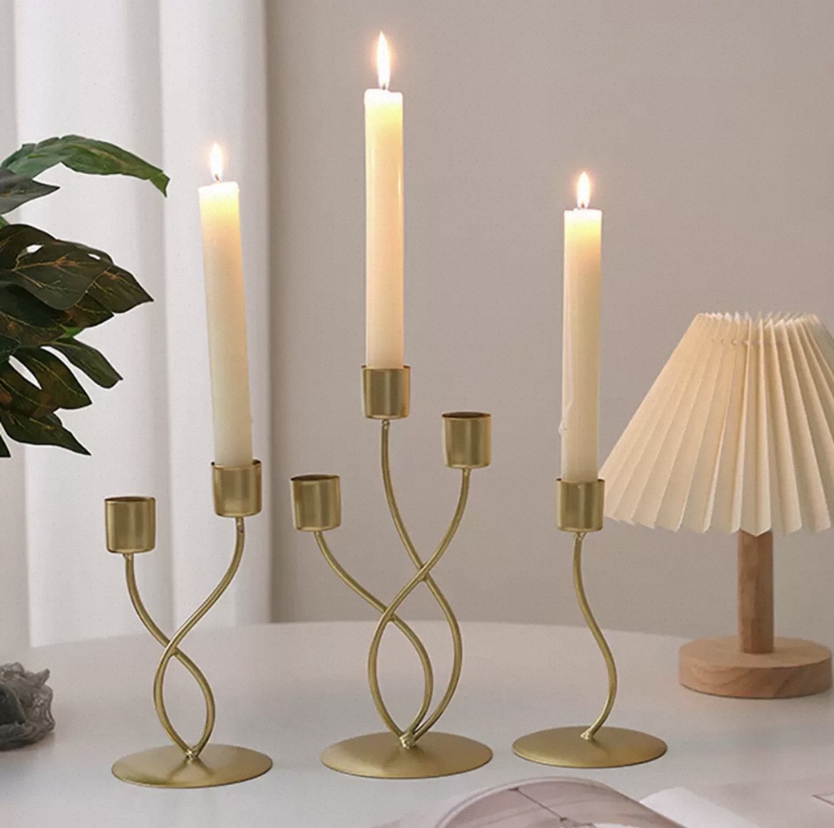 Gold intertwined tulip candelabra holding three lit taper candles