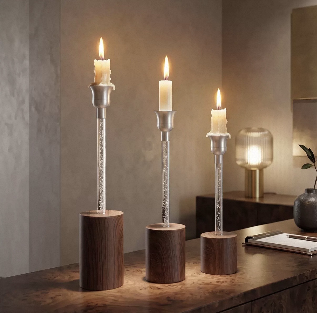 Silver candlesticks with crystal bubble stems and wood bases holding lit tapers