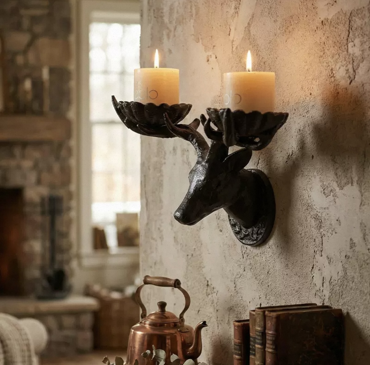 Dark sculptural deer wall-mounted candle holder with two pillar candles