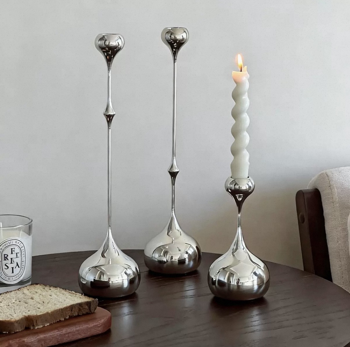 Polished silver teardrop candlesticks with a spiral taper candle