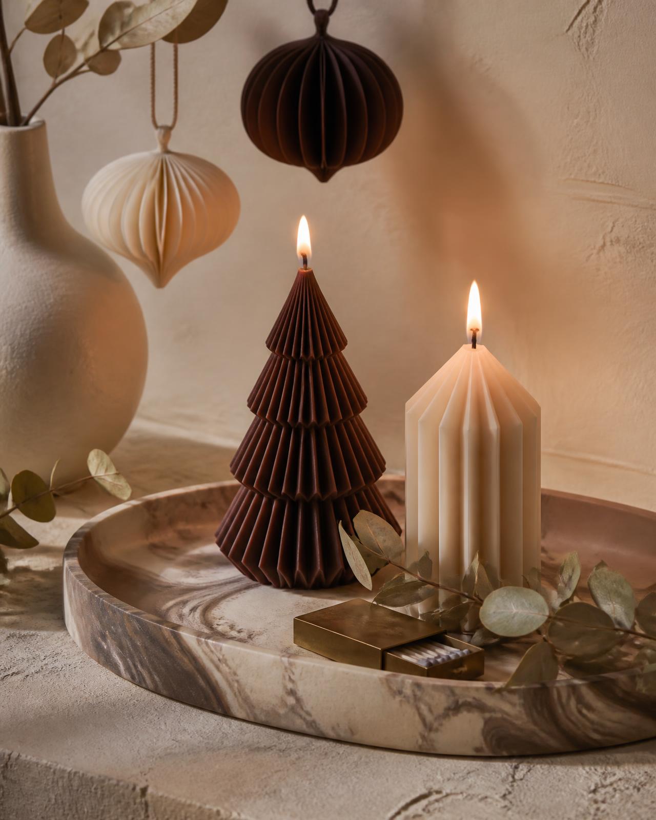 Seasonal Nuvè candles lit on a marbled tray with dried eucalyptus